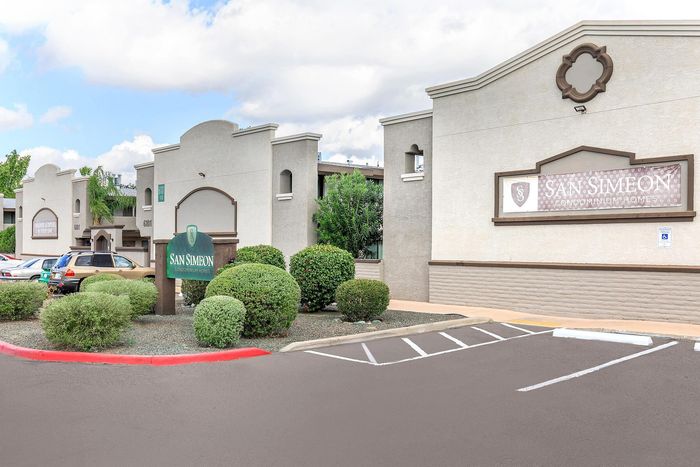 Elegant exterior view of San Simeon Condominium Homes with beautifully landscaped greenery and ample parking space.