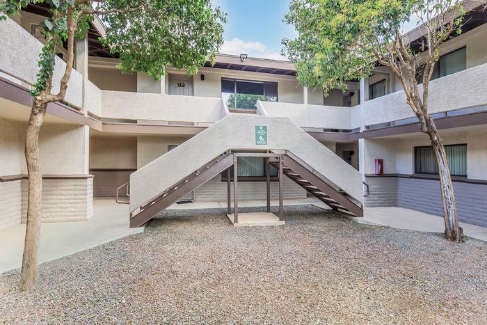 Charming apartment complex courtyard with well-maintained landscaping, featuring modern architecture and inviting pathways.