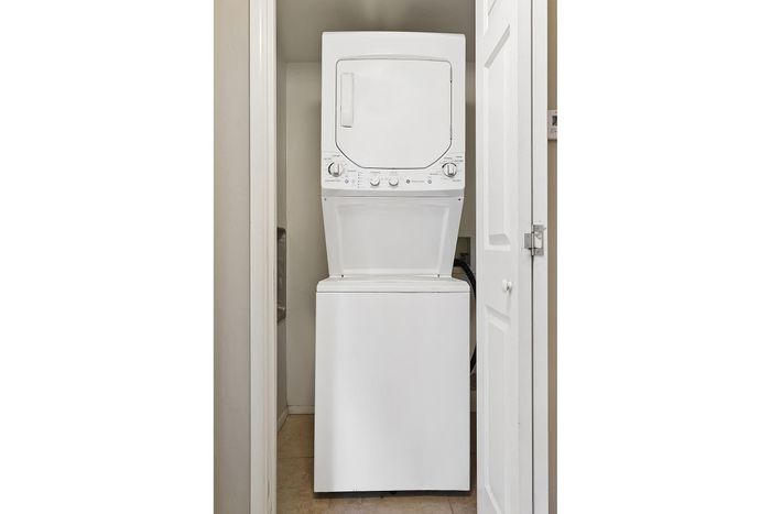 Modern apartment feature showcasing a compact, stacked washer and dryer set in a sleek laundry closet.
