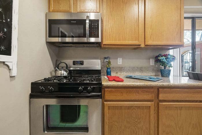 Modern kitchen with sleek stainless-steel appliances, elegant wooden cabinetry, and a window view, perfect for culinary inspiration.