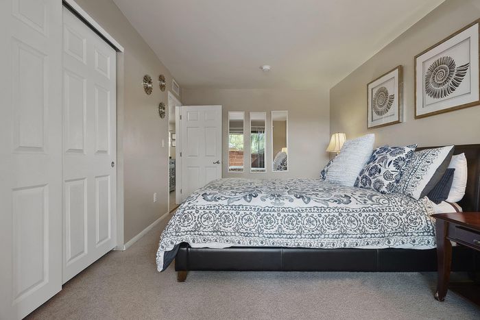 Inviting bedroom with elegant floral bedding, ambient lighting, and stylish decor, perfect for relaxation and comfort.