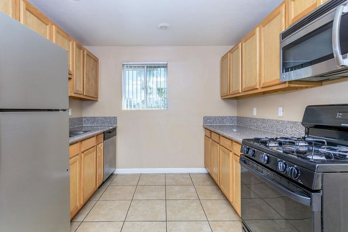Modern kitchen with sleek stainless steel appliances, ample natural light, and elegant granite countertops.
