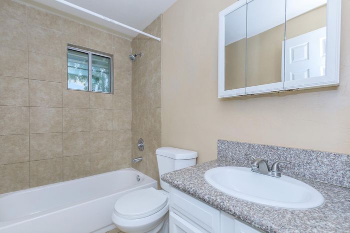 Elegant bathroom with modern fixtures, featuring a sleek granite countertop and a tiled shower area.