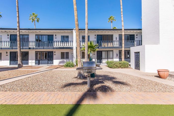 Community courtyard with outdoor grill and palm trees at Miramonte on 3rd apartments, Tucson