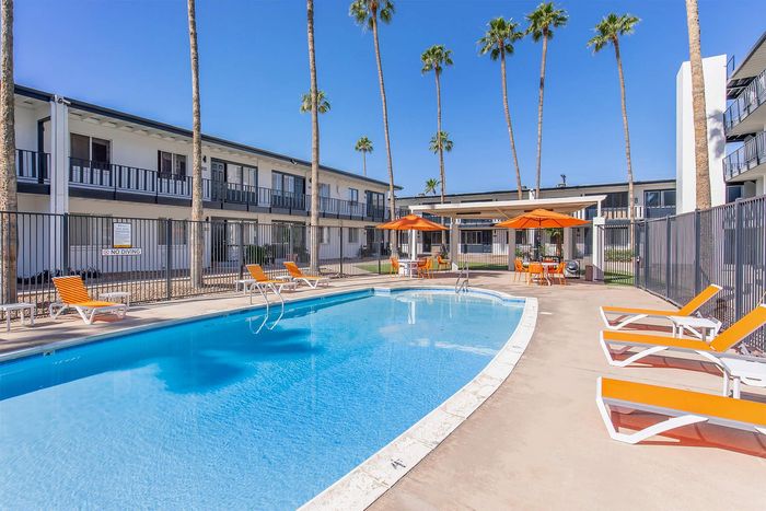 Poolside seating with orange loungers and shade umbrellas at Miramonte on 3rd, Tucson AZ