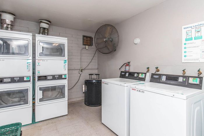 Modern laundry room featuring stacked dryers, efficient washers, and contemporary amenities for convenient living.