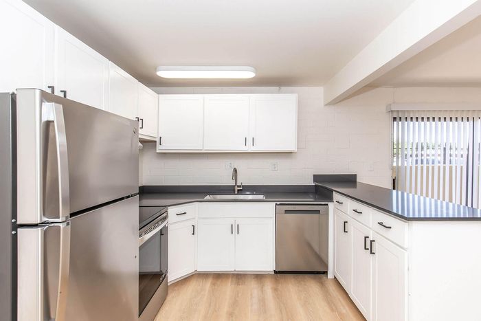 Bright modern kitchen featuring sleek stainless steel appliances, elegant white cabinetry, and expansive counter space.