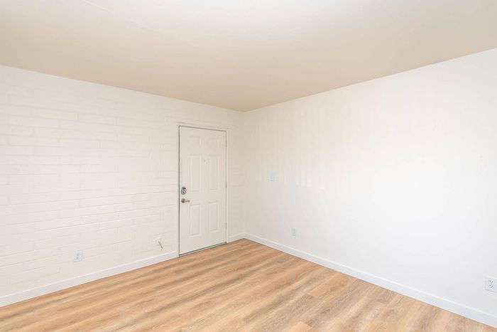 Bright entryway with modern light wood flooring and crisp white walls.