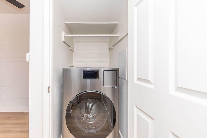 Modern laundry space with sleek stainless steel washer, bright and efficient design for urban living.