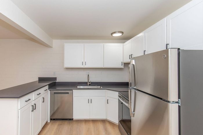 Modern kitchen with sleek stainless steel appliances, crisp white cabinetry, and spacious countertops.