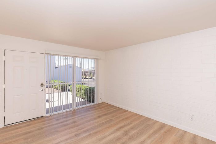 Bright room with large windows and elegant hardwood flooring, offering abundant natural light and modern style.