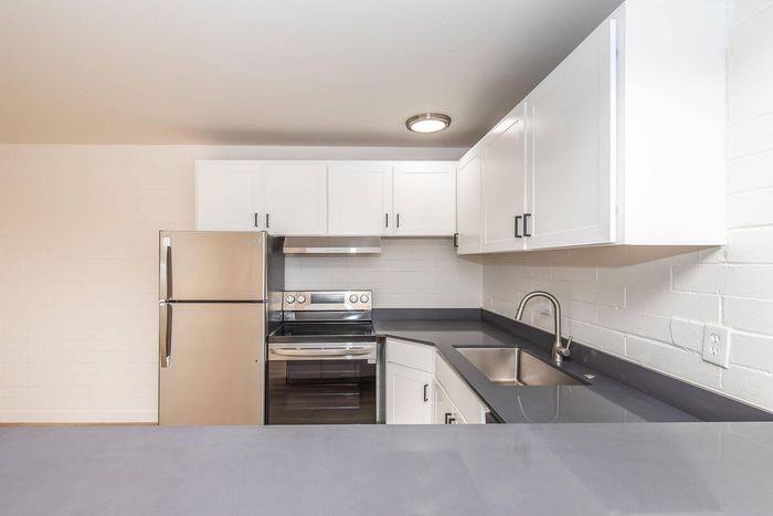 Modern kitchen with sleek stainless steel appliances, elegant white cabinetry, and polished countertops.