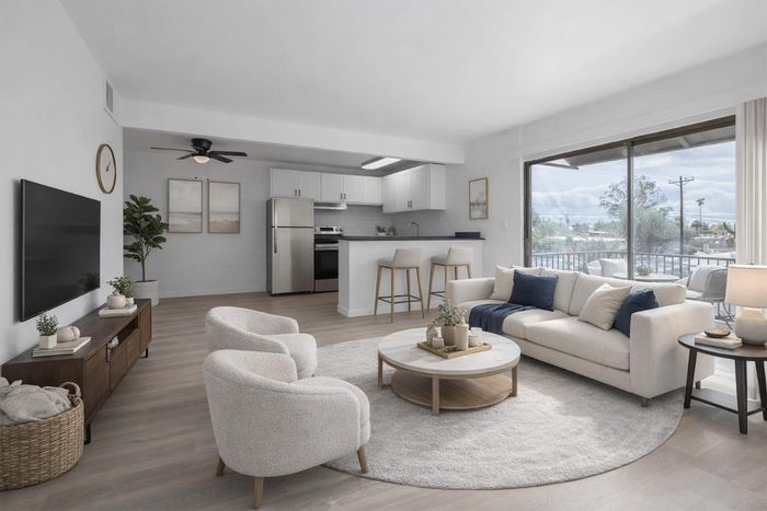 Elegant open-concept living room with modern furnishings, spacious kitchen, and large windows offering scenic views.