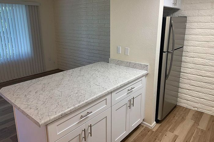 Modern kitchen showcasing sleek marble countertops, stylish white cabinetry, and stainless steel appliances.