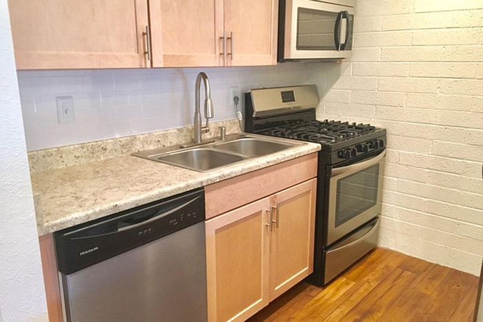 Modern kitchen featuring stainless steel appliances, elegant wooden cabinets, and a sleek granite countertop.