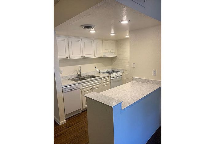 Charming kitchen with elegant white cabinetry, modern appliances, and a sleek countertop, perfect for culinary enthusiasts.