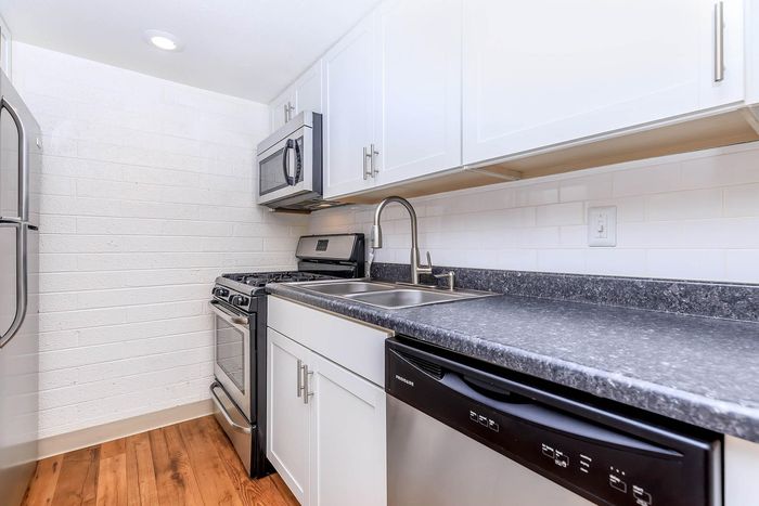Modern kitchen with sleek stainless steel appliances, elegant white cabinetry, and durable granite countertops.