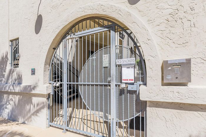 Charming apartment entrance with secure gated access and classic arch design.