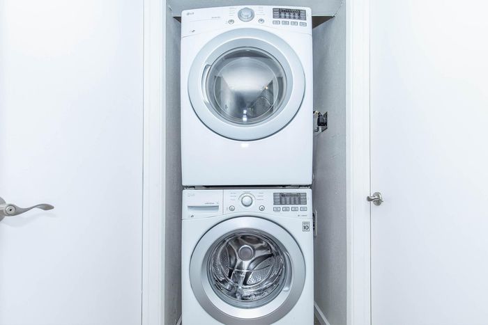 Convenient in-unit laundry with modern stacked washer and dryer, optimized for efficient space use.