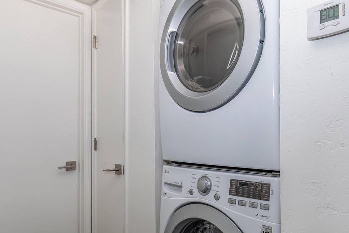 Modern apartment laundry area with a sleek, stackable washer and dryer, enhancing convenience and space efficiency.