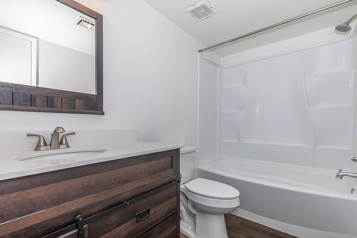 Elegant bathroom with a sleek vanity, modern faucet, and spacious bathtub.