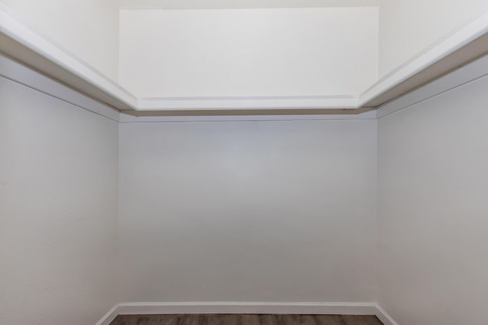 Spacious empty closet with elegant white walls and clean lines, perfect for organizing your wardrobe.