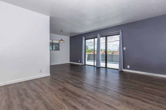 Modern open-concept living space featuring elegant hardwood floors and large windows with an abundance of natural light.
