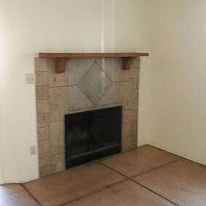Charming living space featuring a classic stone fireplace with a wooden mantel, perfect for a cozy atmosphere.