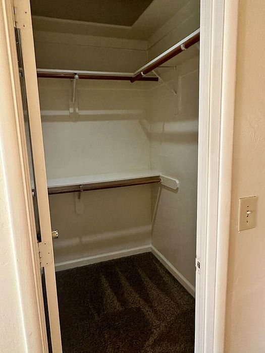 Spacious walk-in closet with ample shelving and hanging space for organized storage.
