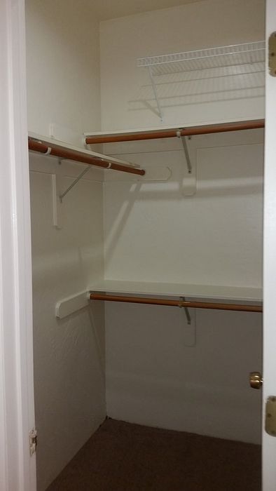 Spacious walk-in closet with ample shelving and hanging space, perfect for organized living.