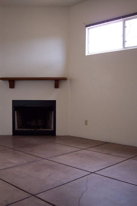 Charming room featuring a cozy fireplace with a wooden mantle and sleek tiled flooring, perfect for creating a warm ambiance.