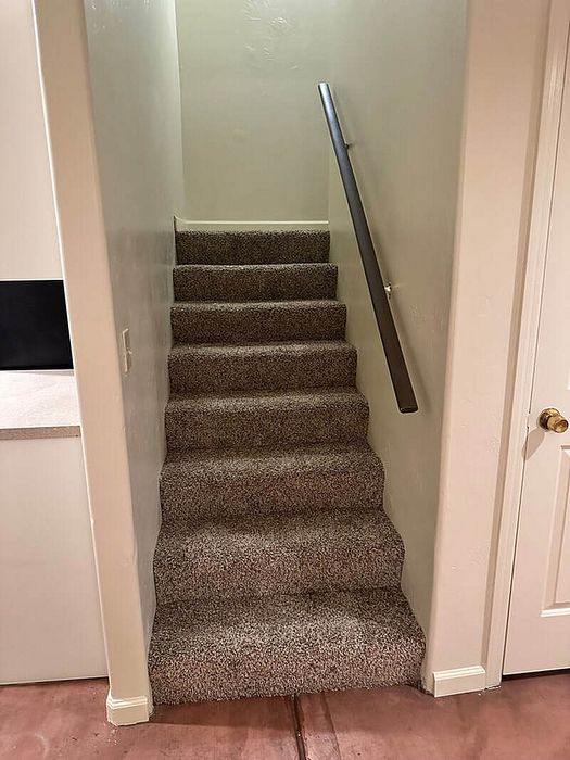 Modern apartment feature with plush carpeted staircase, sleek handrail, and elegant interior details.