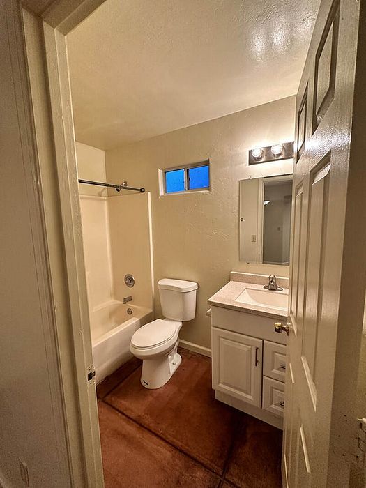 Cozy bathroom featuring a pristine bathtub, modern sink with vanity, and soft lighting for a relaxed ambiance.