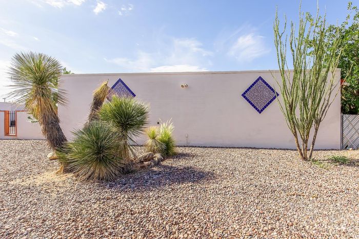Tranquil desert landscape with unique architecture, featuring vibrant tiles and desert plants under a clear blue sky.