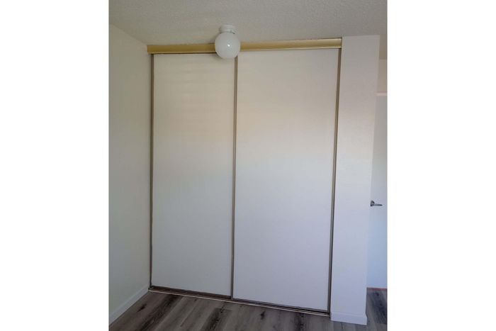 Modern apartment interior showcasing sleek sliding closet doors with elegant trim, accented by stylish light wood flooring.