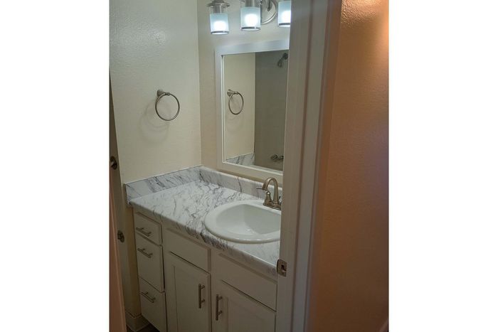 Elegant bathroom with a sleek marble countertop, modern fixtures, and ample storage space.