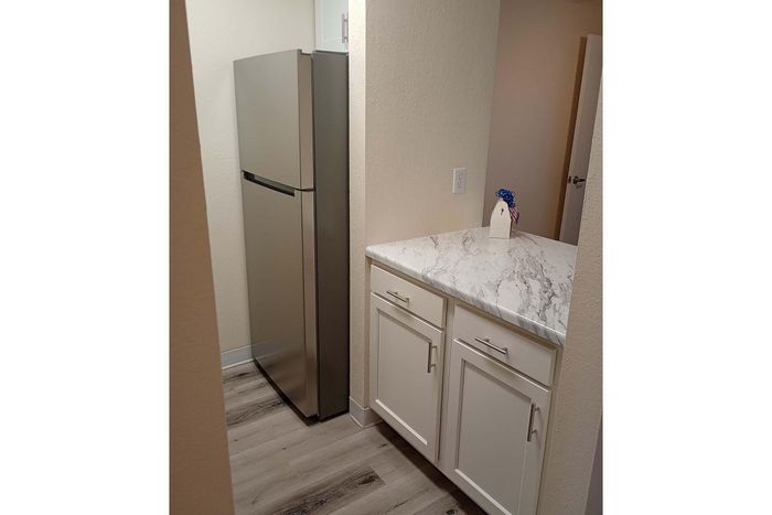 Chic kitchen nook featuring modern stainless steel refrigerator and elegant marble countertop.