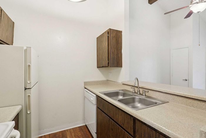 Charming kitchen with sleek countertops, modern double sink, and wood cabinetry, perfect for culinary adventures.