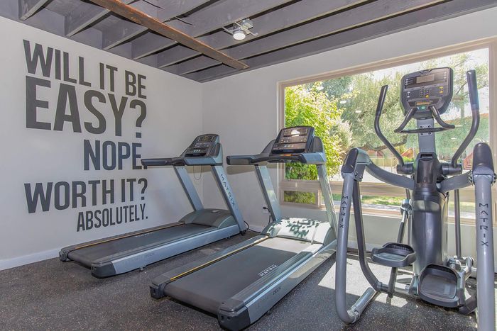 Bright and motivational gym space with modern treadmills and an elliptical machine, perfect for energizing workouts.