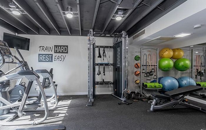 Modern fitness center with state-of-the-art equipment, vibrant exercise balls, and motivational wall art.
