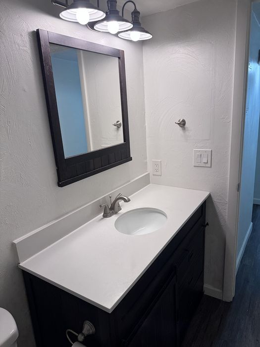 Modern bathroom with elegant vanity, sleek mirror, and stylish lighting.