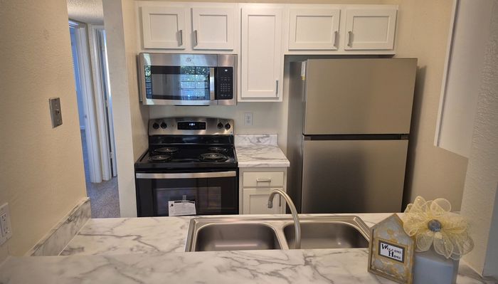 Modern kitchen with sleek stainless steel appliances, elegant marble countertops, and charming decorative touches.
