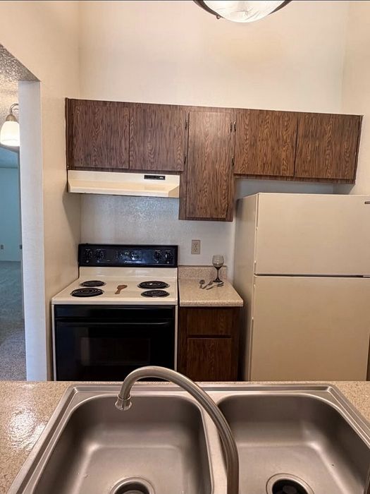 Charming kitchen space with vintage cabinets, modern appliances, and a dual sink setup.