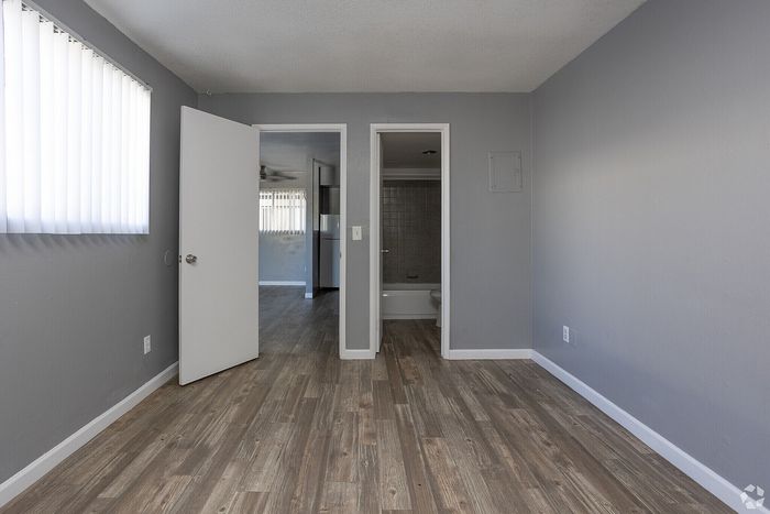 Bright and airy room featuring sleek wood floors and contemporary finishes, leading to a modern bathroom.