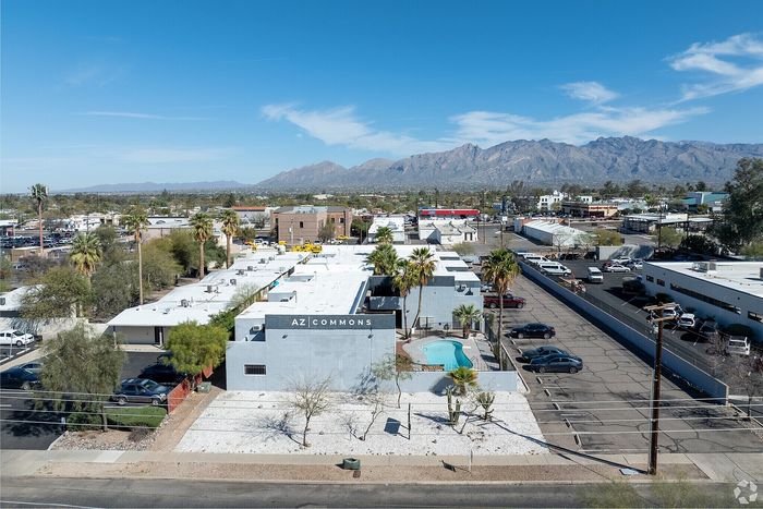 Scenic aerial view of AZ Commons with a sparkling pool, desert landscaping, and mountain backdrop, situated in a vibrant neighborhood.