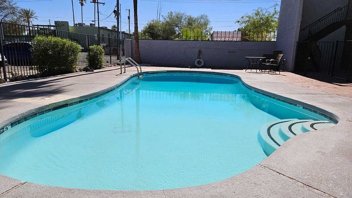 Inviting outdoor swimming pool with serene surroundings and comfortable seating, perfect for relaxation and enjoyment.