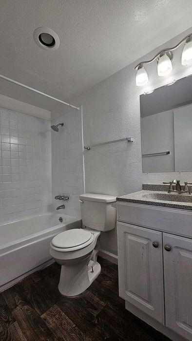 Modern bathroom with elegant lighting, sleek marble countertop, and stylish wood flooring.