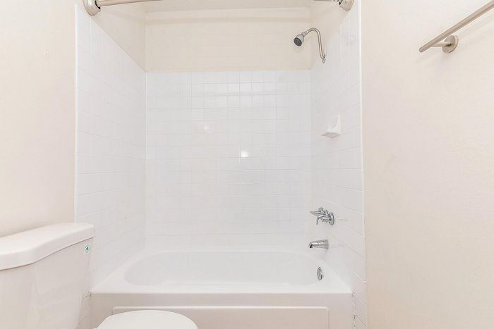 Bathroom with white bathtub and tiled backsplash at Miramonte on 3rd in Tucson, AZ