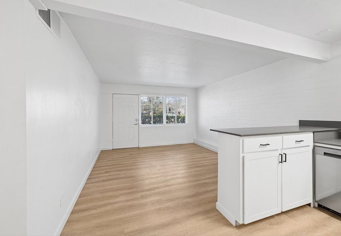 Bright and airy living room with modern wood flooring and white cabinetry at Miramonte on 3rd in Tucson, AZ