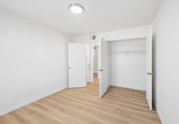 Bright bedroom with modern wood flooring and built-in closet at Miramonte on 3rd in Tucson, AZ